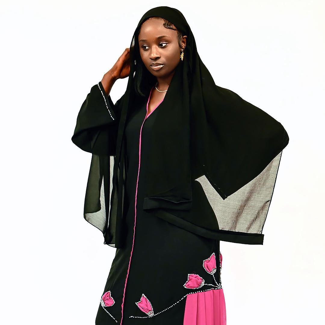 Woman wearing a black and pink traditional outfit with a white background
